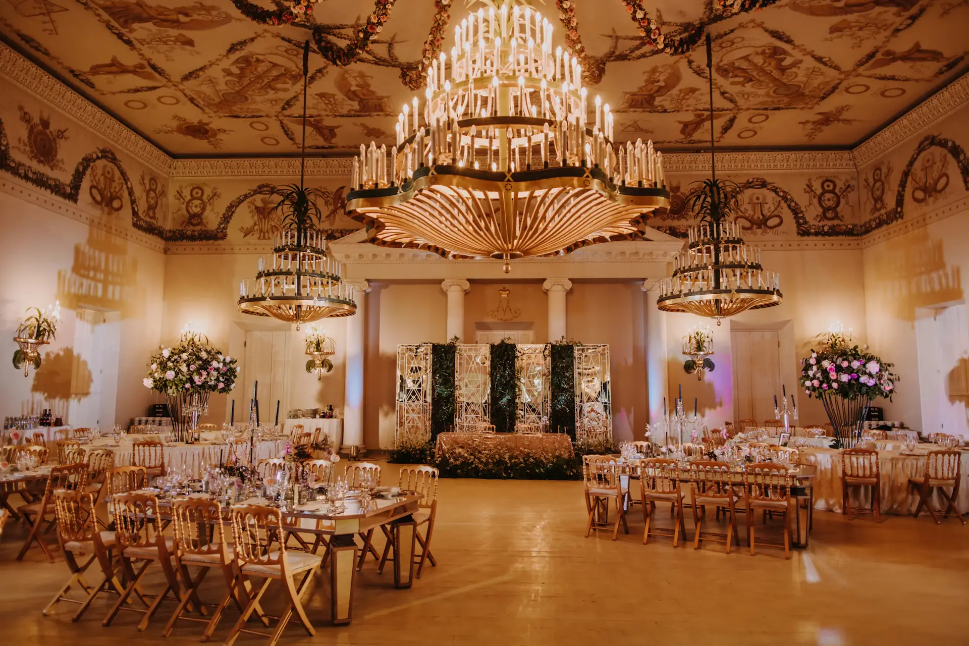 Palace ballroom with candle chandeliers set for a wedding banquet